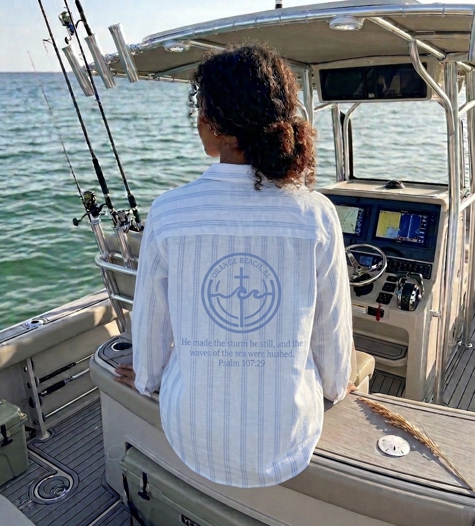 Woman on a fishing boat in an Orange Beach linen shirt with Psalm 107:29 print